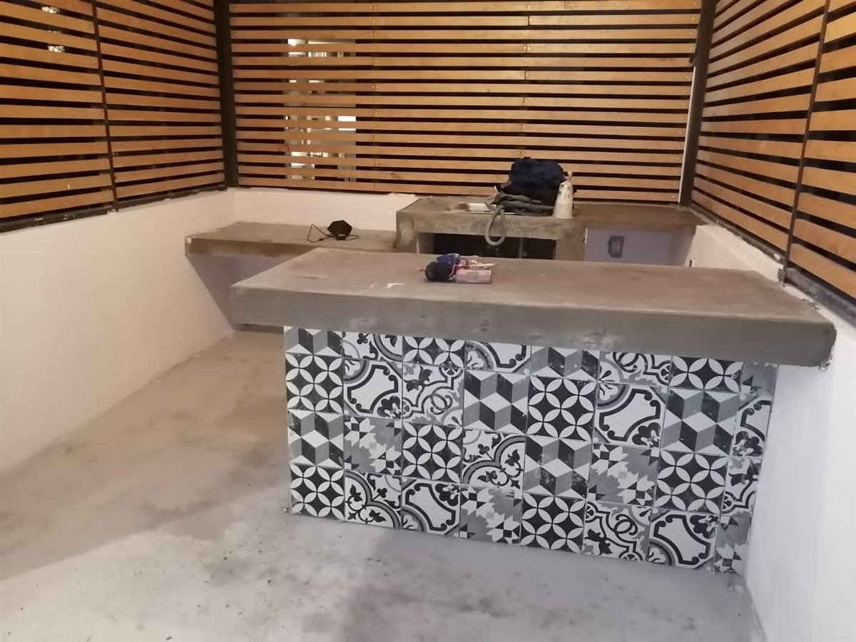 Barra exterior con celosía de madera y azulejo en proceso